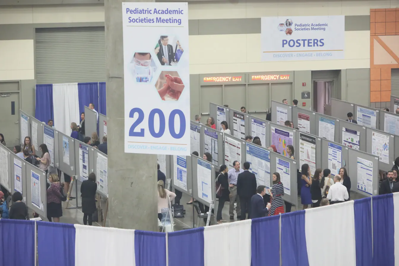 Poster hall at the Pediatric Academic Societies Meeting in Baltimore, with aisle 200 banners and attendees reviewing research posters