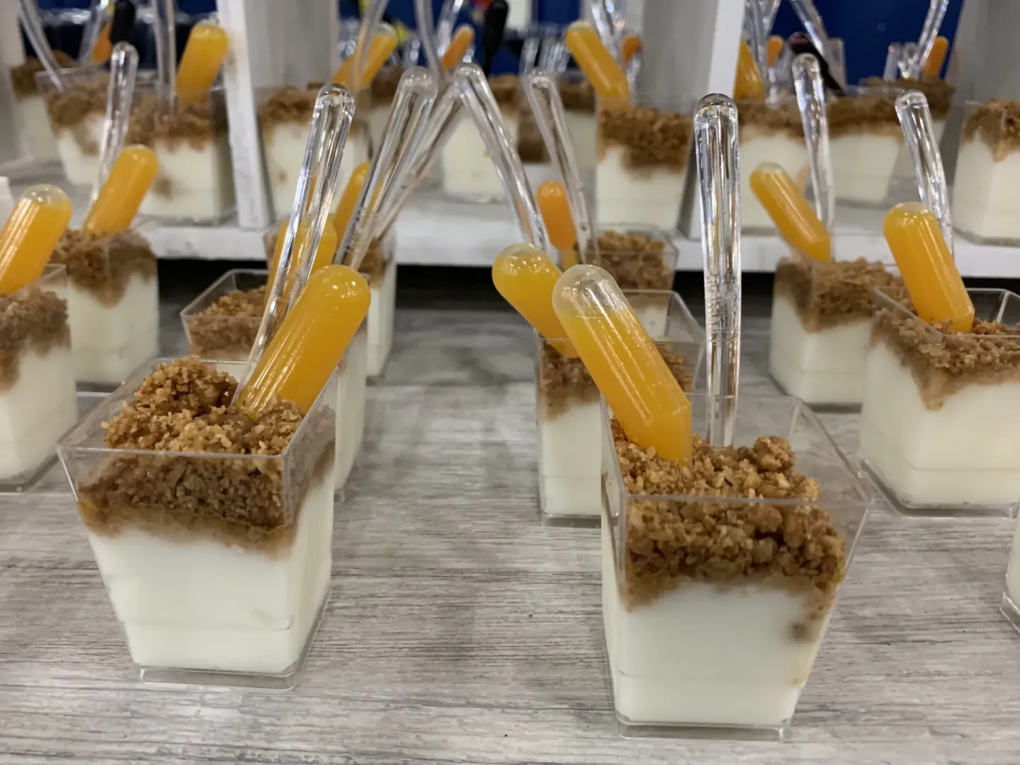 Dessert cups with crumble and juice pipettes on a buffet