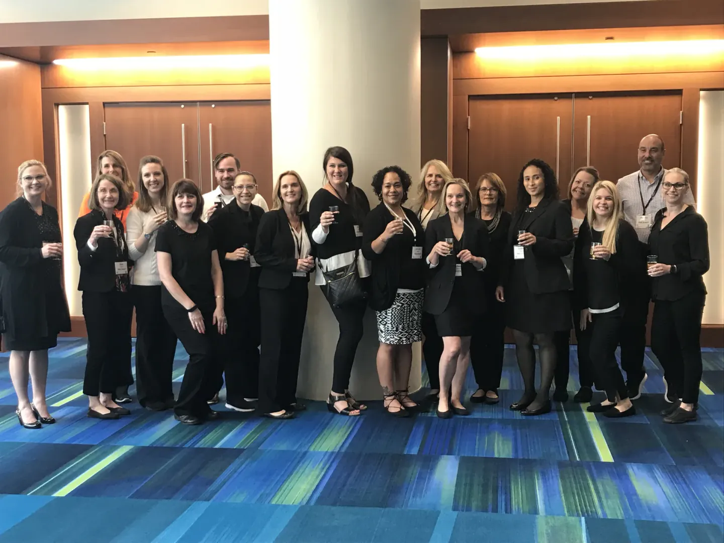 Coterie Spark on-site team toasting together in a hotel foyer