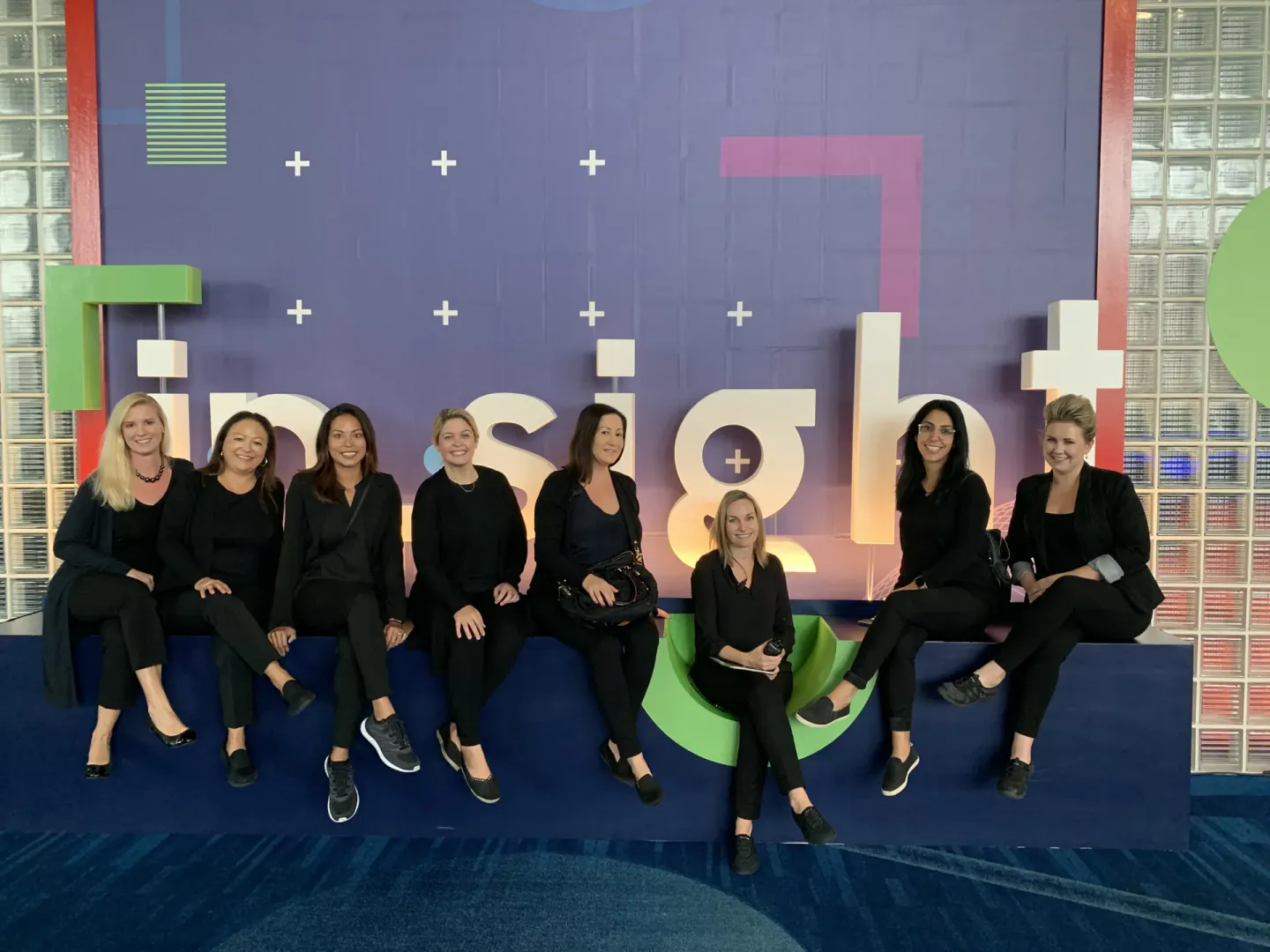 Coterie Spark on-site team seated on the Trimble Insight letter sign