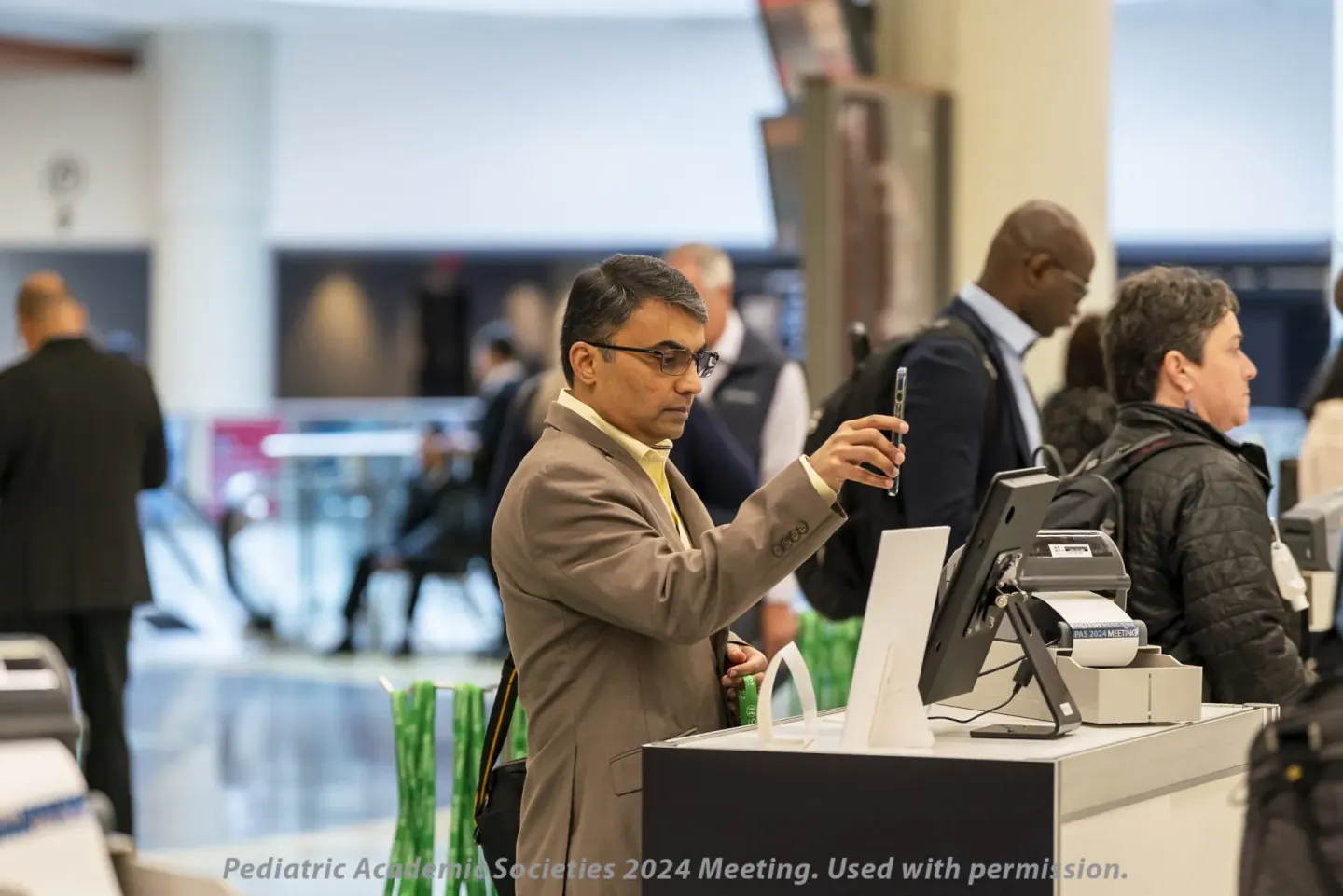 Attendee checking in at a PAS 2024 registration kiosk, Toronto